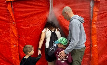 Czteroosobowa rodzina wchodząca do czerwonego namiotu.